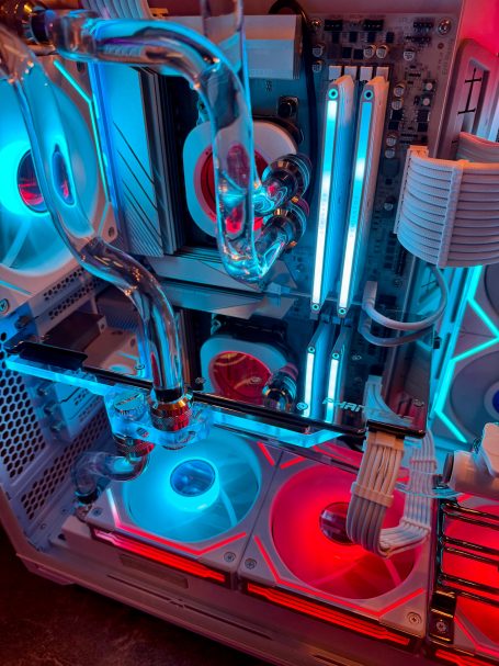 Detailansicht eines Computergehäuses mit blauen und roten LED-Lüftern und Wasserkühlung.