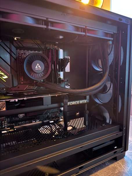 Ein schwarzer Computer-Gehäuse mit sichtbarer Kühlung und Kabeln.