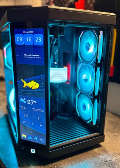 Ein beleuchteter PC-Gehäuse mit sichtbaren RGB-Lüftern und Bildschirmanzeigen.