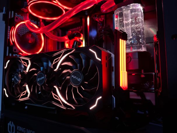 Ein Gaming-PC mit leuchtenden roten und weißen LED-Beleuchtungen und Wasserkühlung.