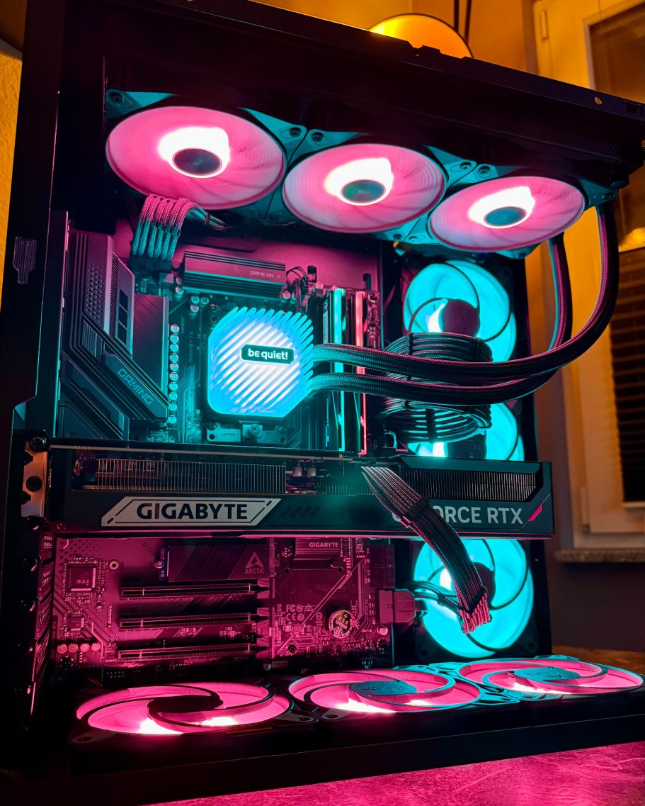Ein beleuchteter Gaming-PC mit rosa und blauen Lüftern und einem Grafikkartenkühler.