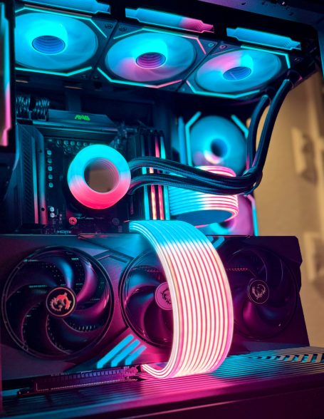 Ein PC-Gehäuse mit RGB-beleuchtetem Kühlsystem und Lüftern in blau-rosa Farben.