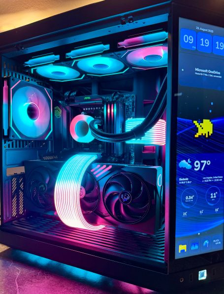 Gaming-PC mit bunten RGB-Lichtern und Monitor, der Wetterdaten anzeigt.